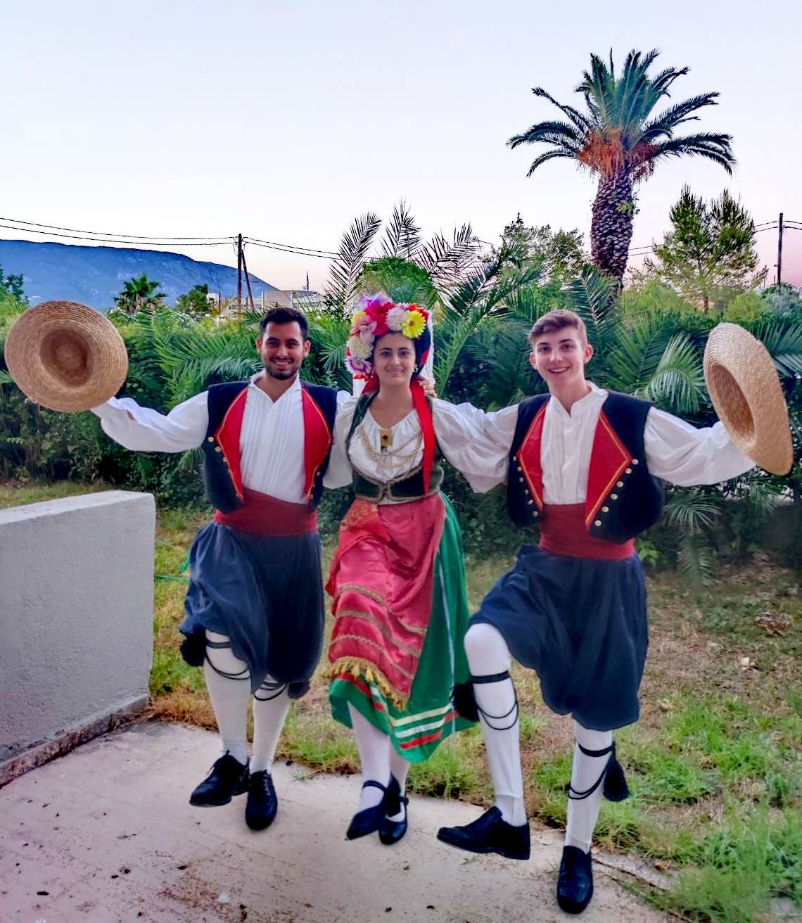 Two people in Corfiot costume, one wearing a wreath of flowers.