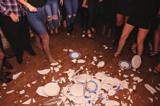 Broken plates on the floor after plate smashing.